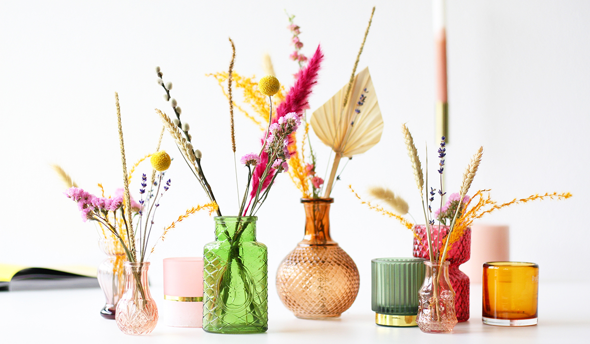 Kleine gekleurde vaasjes gevuld met droogbloemen