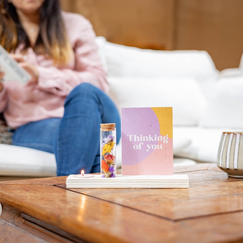 cadeau op tafel met kaarsje en kaart met tekst 'thinking of you'