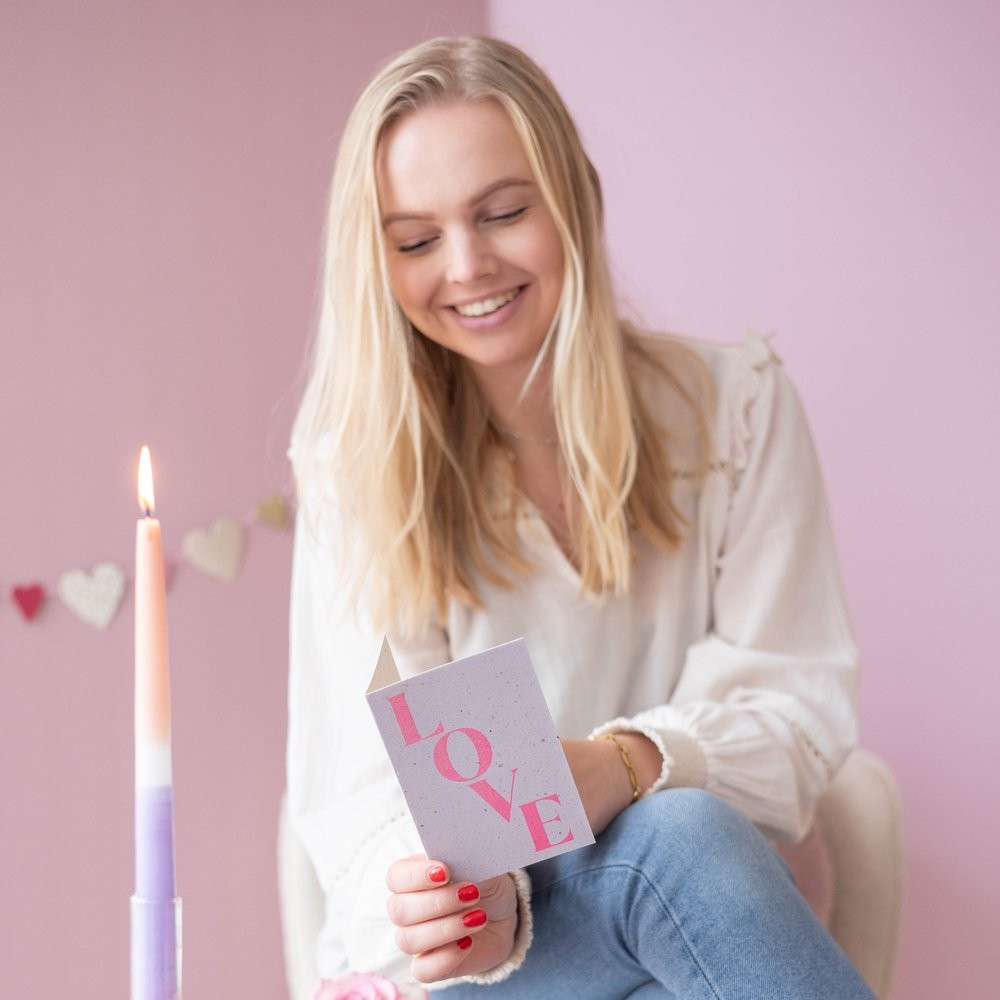 vrouw leest wenskaart met tekst Love