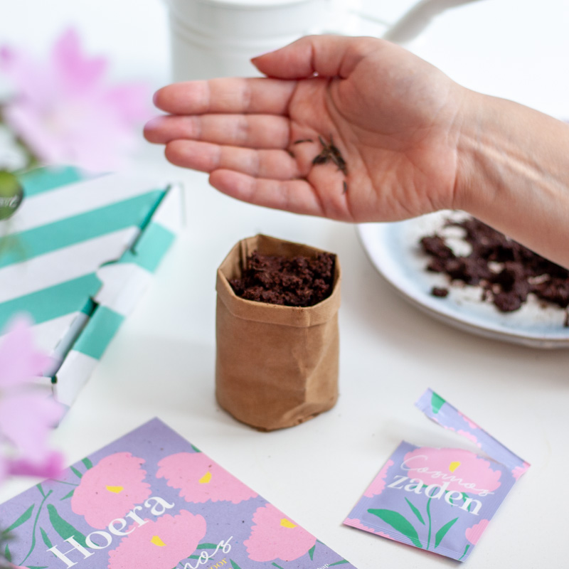 hand met zaadjes en kaartje 'hoera'