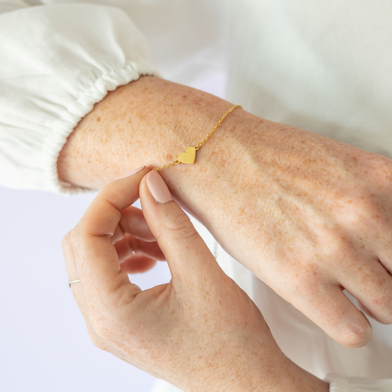 goudkleurige hartjesarmband om pols