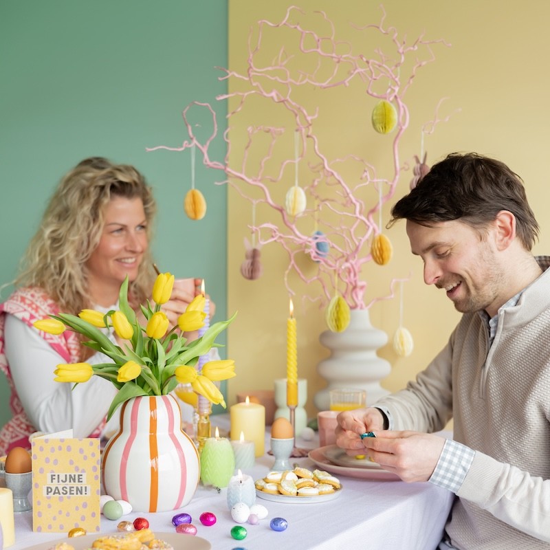 Gele tulpen op gedekte tafel Pasen