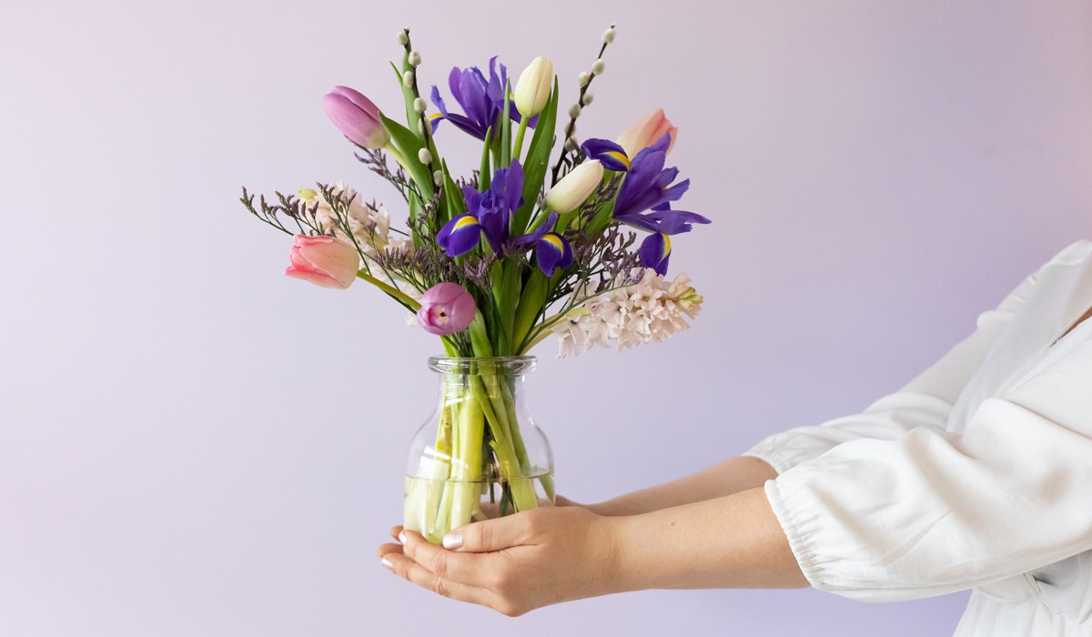 vaas met bloemen in handen van vrouw