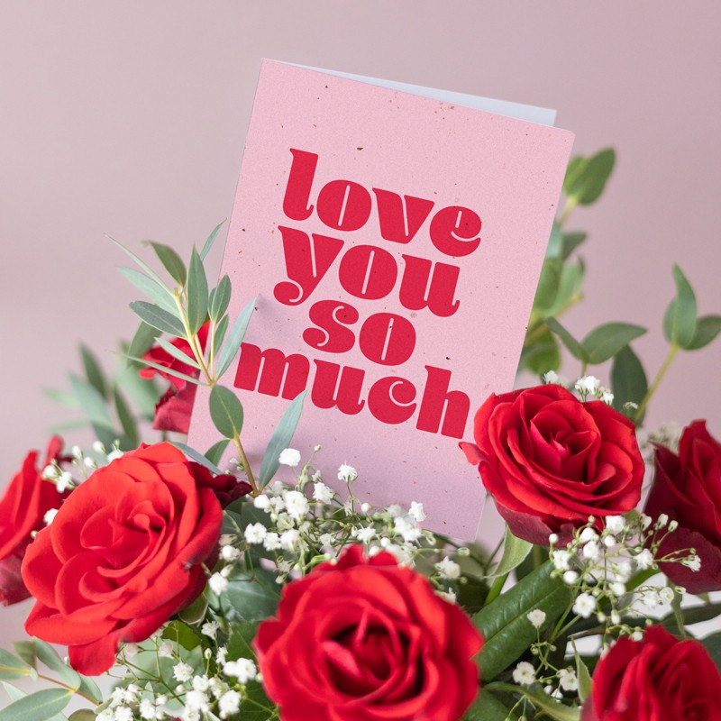 Rode rozen met gipskruid en wenskaart met tekst 'love you so much'