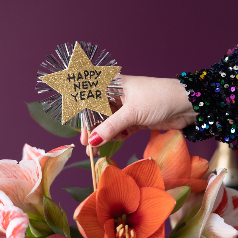 Amaryllis met daarin een gouden steker met tekst 'Happy new year'