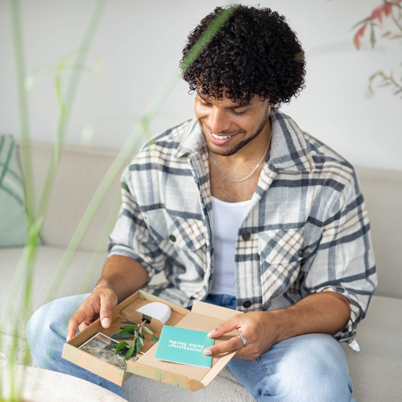Man pakt brievenbuscadeau met boompje uit