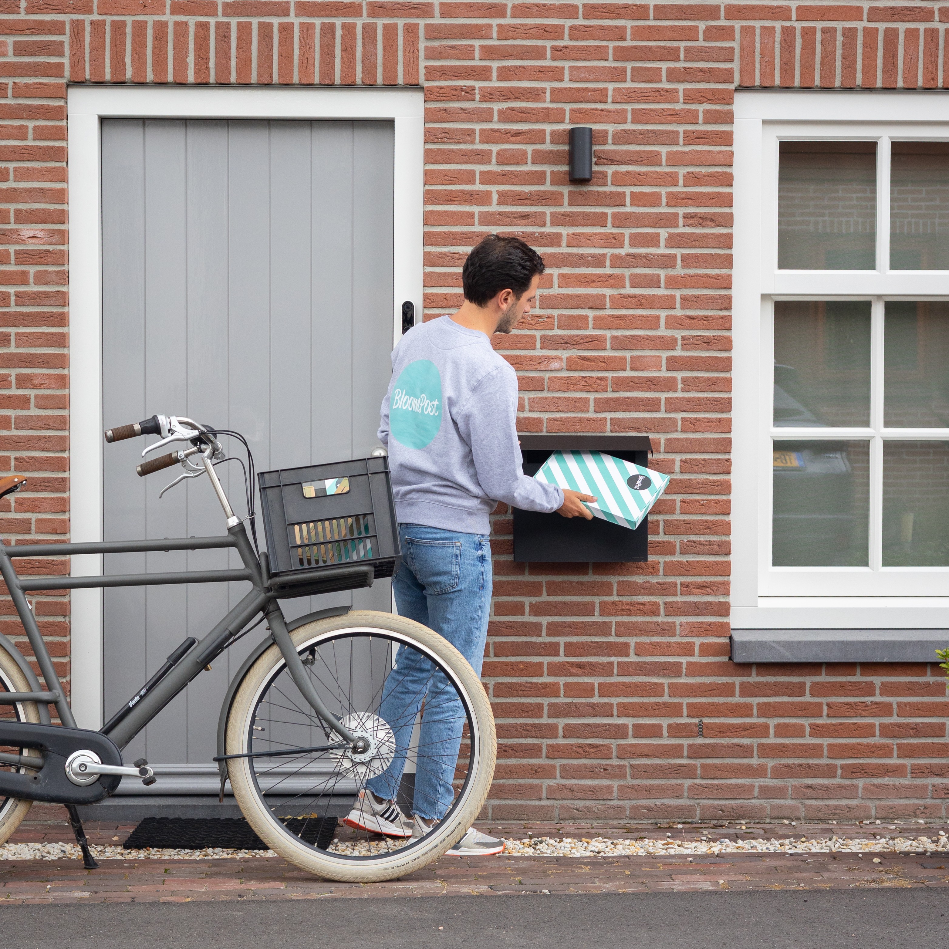Man bezorgt pakketje door de brievenbus 